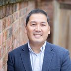 Head and shoulders portrait of Timothy Ng, founder of Scryla, wearing a dark suit